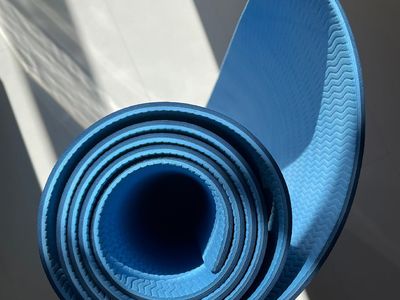 Modern yoga mat rolled up in a bright room.